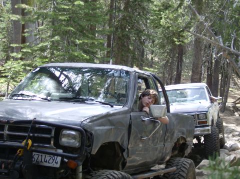 1986 Ford Bronco - A 1986 Ford Bronco is seen in a wooded area with a young person asleep at the wheel.