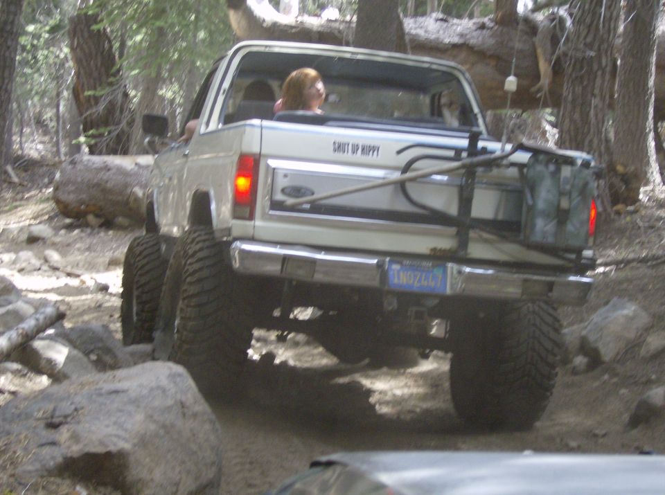 White 1986 Ford Bronco rear view on rocky trail