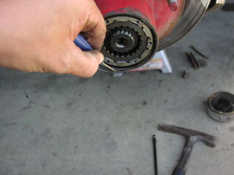 1981 Ford Bronco - Close-up of a hand working on a vehicle's hub assembly, showing internal splines.