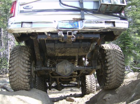 1986 Ford Bronco - Rear view of a 1986 Ford Bronco's suspension and axle while off-roading on rocks.