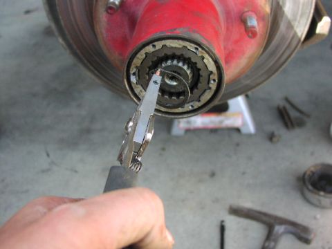 1981 Ford Bronco - Pliers are used to remove a clip from the front wheel hub assembly during a repair.