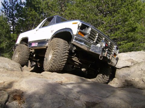 1986 Ford Bronco - This modified 1980s Ford Bronco navigates a rocky trail with its suspension articulated.