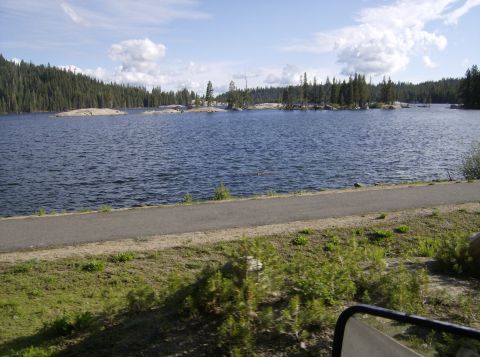 1986 Ford Bronco - A scenic view of a lake surrounded by trees under a partly cloudy sky.