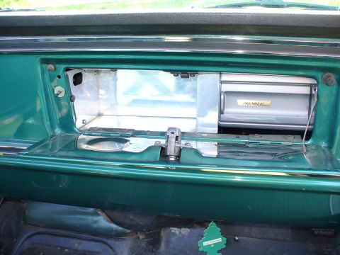 1978 Ford Bronco - Interior view of a car's dashboard, showing an open glove box with a cassette player inside.