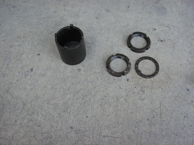 Black hub socket tool and three notched lock rings on concrete