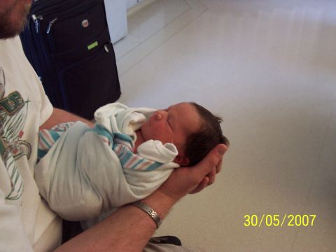 2000 Ford Crown Victoria - A person holds a newborn baby wrapped in a blanket. The photo has a date stamp of 30/05/2007.