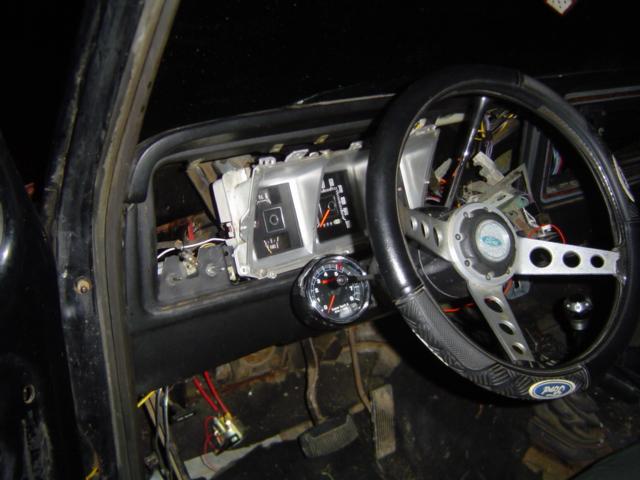 1979 Ford Bronco interior showing dashboard, steering wheel, and aftermarket gauge