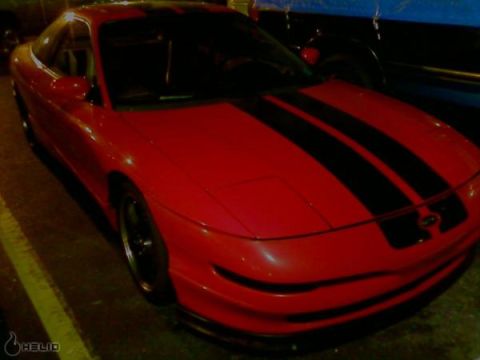 1993 Ford Probe - A red 1993 Ford Probe with black racing stripes is parked, showing its front 3/4 view.