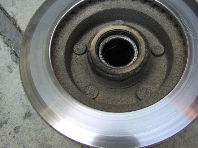 Machined brake rotor with rusty hub, lug studs, and center bearing bore