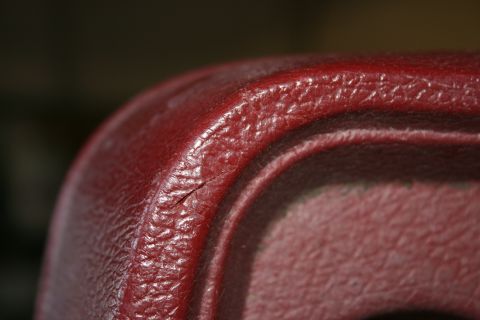 1985 Ford F-150 - Cracked red plastic trim detail, likely an interior component.