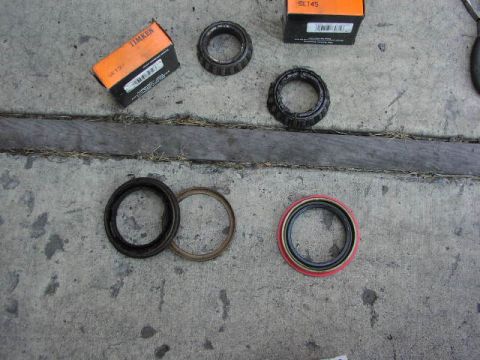 1981 Ford Bronco - Wheel bearings and seals are laid out on a concrete surface, with two boxes in the background.