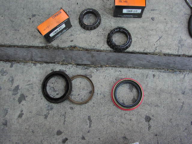 New and used Timken wheel bearings and hub seals laid out on concrete