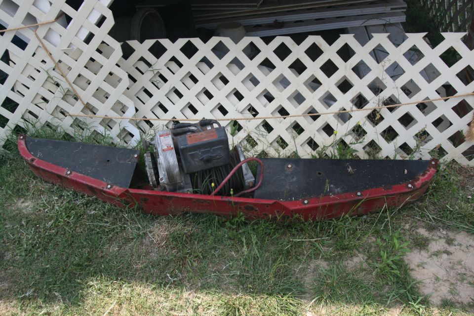 Red snowmobile plow with engine and black top surface