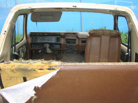 1981 Ford Bronco - The interior of this vehicle shows significant wear and tear, with exposed foam and a worn dashboard.