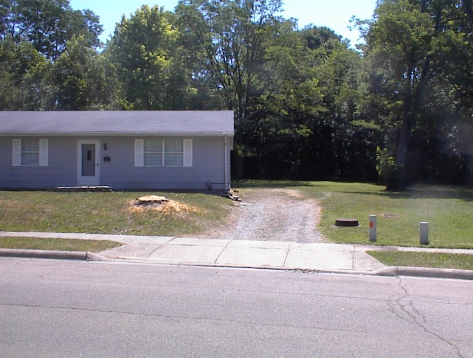 Suburban house with a gravel driveway and sidewalk in front