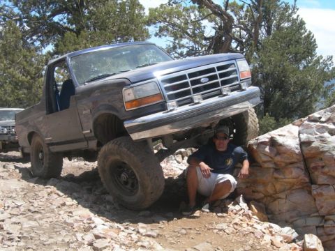 1994 Ford Bronco - This Ford Bronco is navigating a difficult rocky terrain, with a person resting nearby.