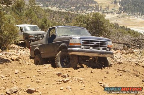 1994 Ford Bronco - A 1994 Ford Bronco tackles a challenging off-road path, with a second vehicle following closely behind.