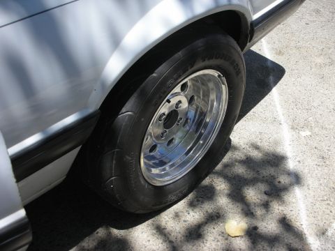1992 Ford Crown Victoria - Drag racing tire and chrome wheel on a white car, likely modified for performance.