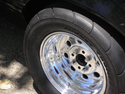 1992 Ford Crown Victoria - A close-up view of a shiny chrome wheel and a black tire on a vehicle.