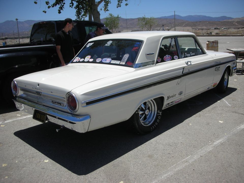 White 1964 Ford Fairlane two-door sedan, rear view, with racing decals and chrome wheels