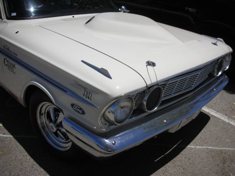 1992 Ford Crown Victoria - Front view of a white 1962 Ford Falcon with a hood scoop and "Vintage Fuel" graphics.