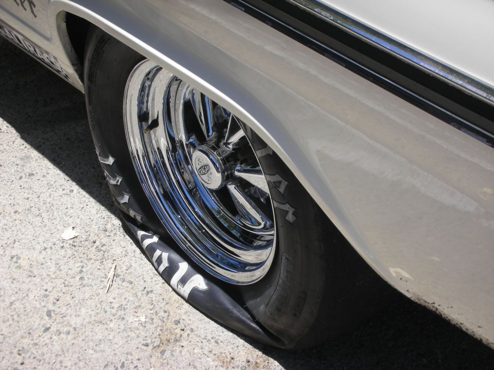 Flat tire on a silver car with chrome wheels