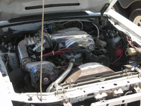 1992 Ford Crown Victoria - Close-up of a modified engine bay a prominent supercharger and polished components.