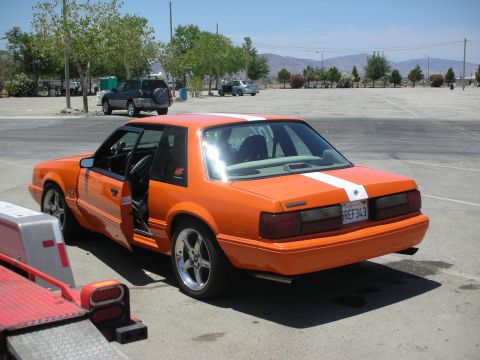 1992 Ford Crown Victoria - Orange coupe with white racing stripes and a license plate reading 'SREF 343'.