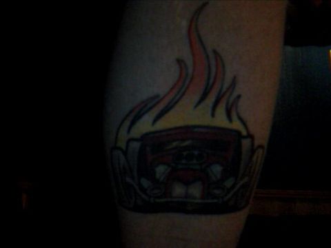 1989 Ford Bronco - A tattoo depicts a stylized hot rod engulfed in flames.