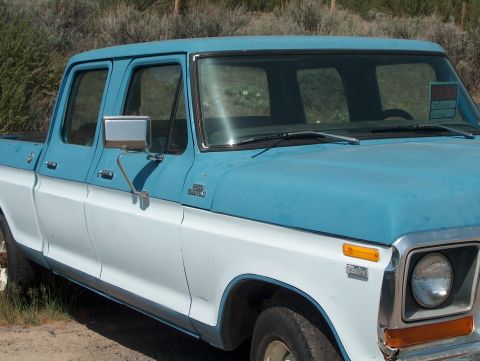 1978 Ford Bronco - This two-tone blue and white 1978 Ford F250 Crew Cab pickup truck is seen from a 3q-front angle, with a "FOR SALE" sign visible in the wind…