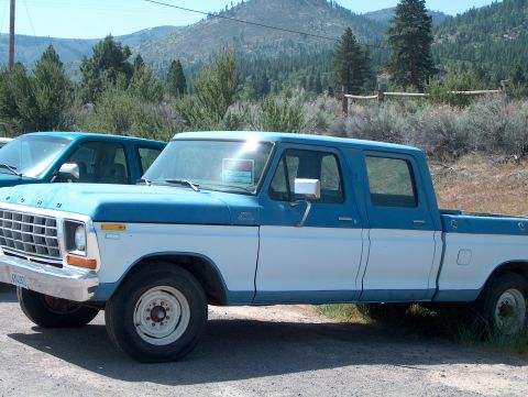 1978 Ford Bronco - A blue and white Ford F-Series pickup truck with a crew cab is parked outdoors next to another vehicle.