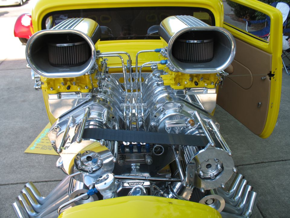 Polished blown V8 engine with dual scoops in a yellow hot rod truck