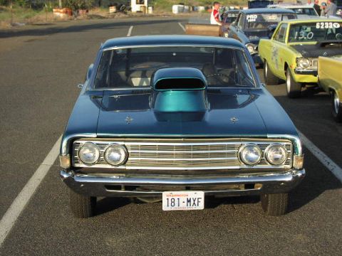1981 Ford Bronco - Front view of a blue 1966 Ford Fairlane with a hood scoop at a drag race event.