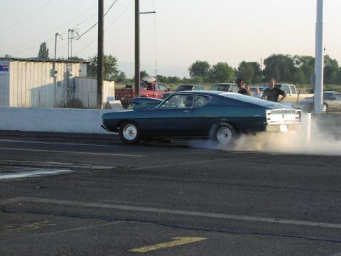 1981 Ford Bronco - A vintage coupe spins its tires, creating a cloud of smoke on the drag strip.