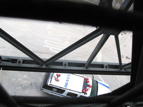 1991 Ford LTD Crown Victoria - Through a metal lattice, a white and blue police car numbered 5340 with roof lights is seen from directly above.