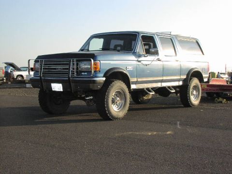 1981 Ford Bronco - This blue SUV, possibly a Ford Bronco, is equipped with a brush guard and side exhaust pipes, seen here in a 3/4 front view.