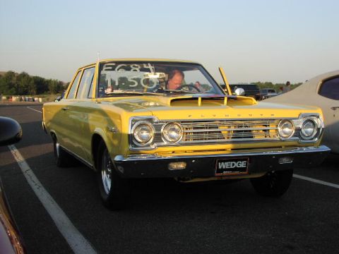 1981 Ford Bronco - A yellow Plymouth Satellite sits on the asphalt, possibly at a drag strip, with a driver behind the wheel.