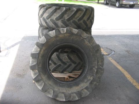 1991 Ford Bronco - Several large tractor tires are stacked on a wooden pallet outdoors on asphalt.