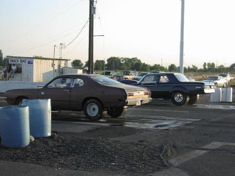 1981 Ford Bronco - Two coupes are lined up on a drag strip with a snack bar in the background.