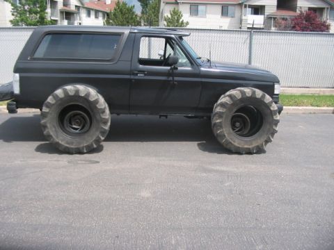 1991 Ford Bronco - This modified SUV features massive tractor tires, giving it a unique and imposing stance.