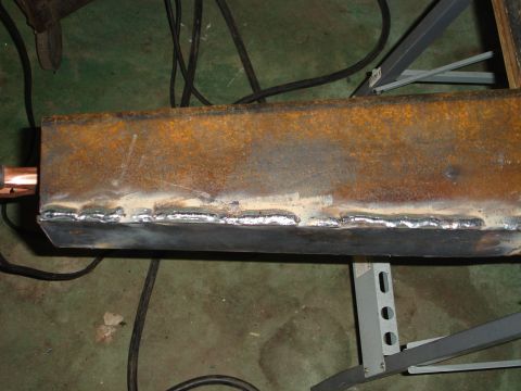 1989 Ford Bronco - A close-up view of a metal beam that has been welded, with a copper pipe extending from one end.