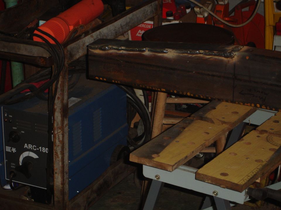 Welding machine and metal beam with welds and markings