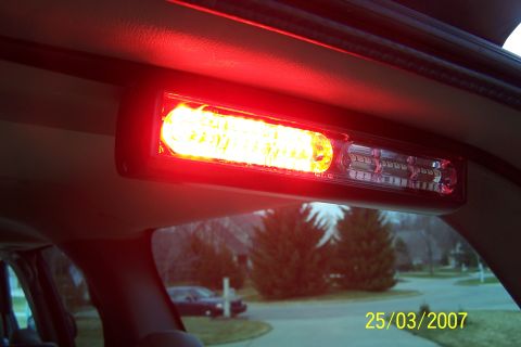 2003 Ford Crown Victoria - Interior view of a vehicle's overhead light bar, with a dark sedan visible through the rear window.
