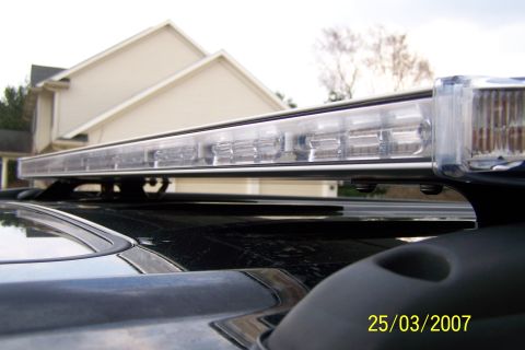 2003 Ford Crown Victoria - A close-up view of a light bar mounted on the roof of a dark-colored vehicle, with a date stamp visible in the lower right corner.