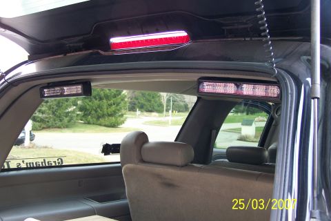 2003 Ford Crown Victoria - Emergency lights are installed inside the rear of a vehicle, visible through the windows.