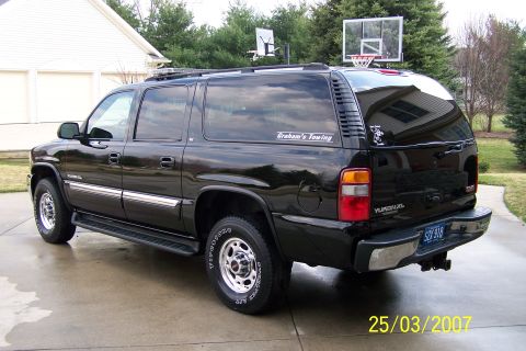 2003 Ford Crown Victoria - This GMC Yukon XL SUV is black with chrome accents and a "Graham's Towing" sticker on the rear window.