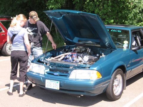 1989 Ford Mustang - A teal 1989 Ford Mustang coupe is displayed with its hood open, revealing the engine bay.