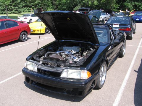 1989 Ford Mustang - 1989 Ford Mustang convertible's engine bay is visible with the hood raised.