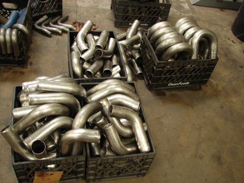 1992 Ford Taurus - Several crates are filled with exhaust pipes, likely for automotive customization or repair.