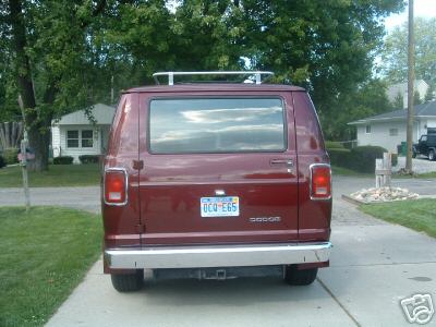 1978 Ford E250 - Rear view of a maroon van, possibly a Dodge Tradesman, with a chrome bumper and roof rack. The license plate is visible.